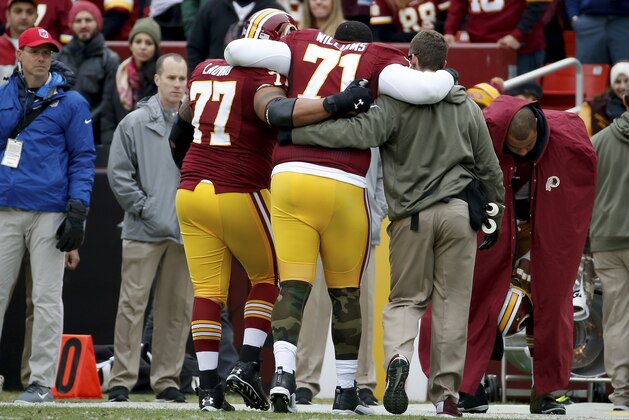 Washington Redskins tackle Trent Williams (71) is helped off the field after an injury during the first half of an NFL football game against the Tampa Bay Buccaneers in Landover, Md., Sunday, Nov. 16, 2014. (AP Photo/Alex Brandon)