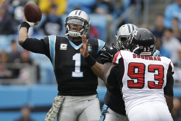 Carolina Panthers' Cam Newton (1) throws a pass under pressure from Atlanta Falcons' Malliciah Goodman (93) in the first half of an NFL football game in Charlotte, N.C., Sunday, Nov. 16, 2014. (AP Photo/Bob Leverone)