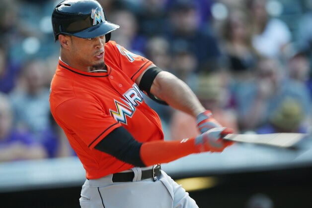 Miami Marlins' Giancarlo Stanton follows the flight of his RBI-single against the Colorado Rockies in the seventh inning of the Rockies' 7-4 victory in a baseball game in Denver on Sunday, Aug. 24, 2014. (AP Photo/David Zalubowski)