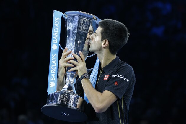 Serbia’s Novak Djokovic kisses the trophy of the ATP World Tour Finals tennis during an improvised presentation ceremony after a walkover due to injury of Switzerland’s Roger Federer in London, Sunday, Nov. 16, 2014. Federer withdrew due to an injured back. (AP Photo/Kirsty Wigglesworth)