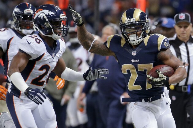 St. Louis Rams running back Tre Mason, right, runs past Denver Broncos free safety Rahim Moore on his way to a 27-yard gain during the second half of an NFL football game, Sunday, Nov. 16, 2014, in St. Louis. (AP Photo/Charlie Riedel)