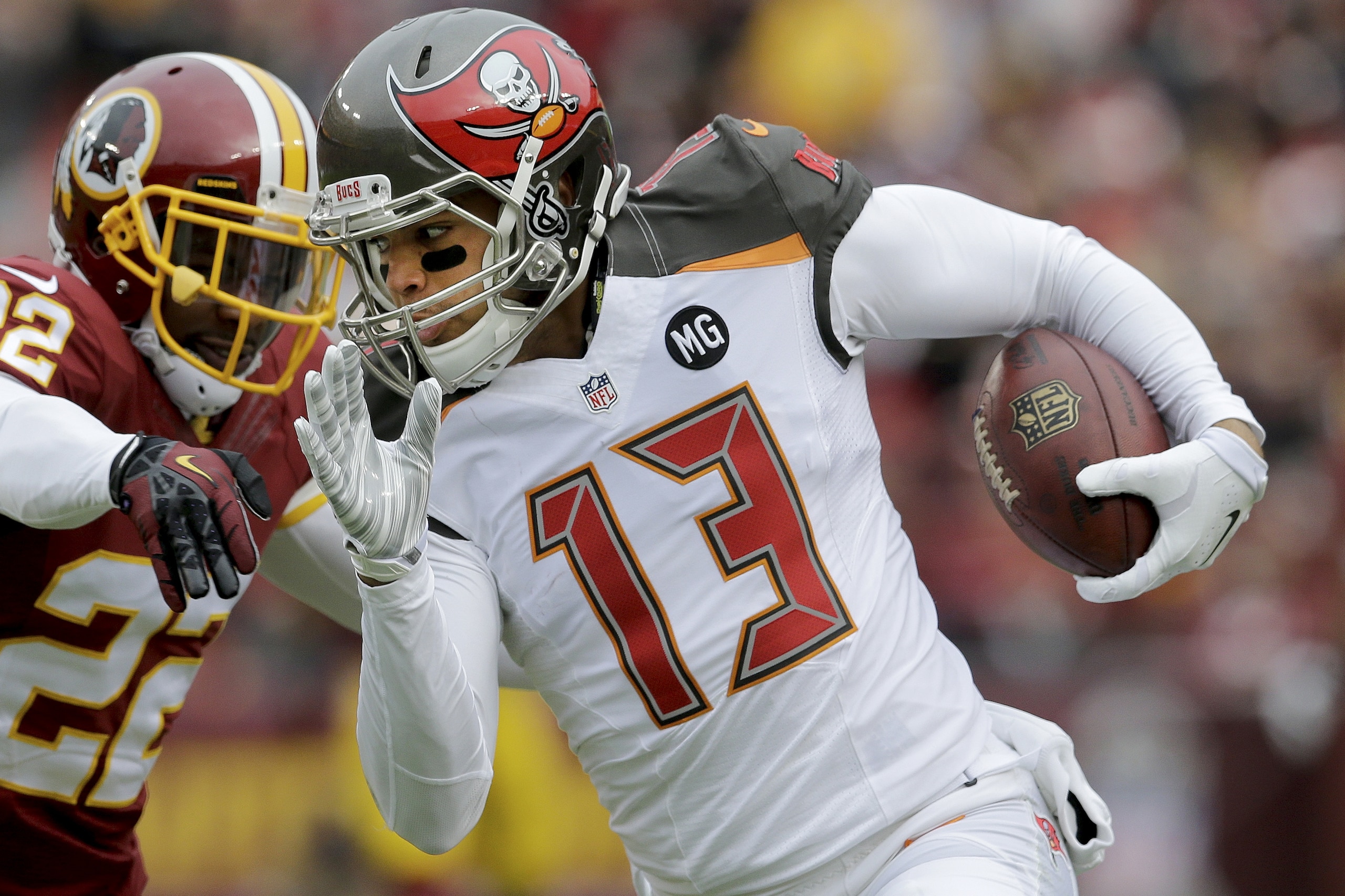 Tampa Bay Buccaneers wide receiver Mike Evans (13) carries the ball past Washington Redskins cornerback Tracy Porter (22) during the first half of an NFL football game in Landover, Md., Sunday, Nov. 16, 2014. (AP Photo/Patrick Semansky)