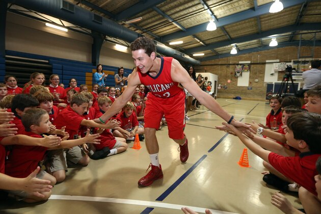 METAIRIE, LA - SEPTEMBER 23:  New Orleans Pelicans Jimmer Fredette slaps hands with children wearing the new Pelican Alternative uniform for a press conference and Junior Training Camp on September 23, 2014 at the St. Catherine's of Siena in Metairie, Louisiana. NOTE TO USER: User expressly acknowledges and agrees that, by downloading and or using this Photograph, user is consenting to the terms and conditions of the Getty Images License Agreement. Mandatory Copyright Notice: Copyright 2013 NBAE (Photo by Layne Murdoch/NBAE via Getty Images)