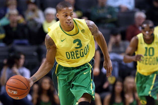 Dressed in a new retro uniform, Oregon's Joseph Young, left, brings the ball down court ahead of teammate Johnathan Loyd, right, against Washington State at Oregon in an NCAA college basketball game in Eugene, Ore. on Sunday, Feb. 23, 2014. (AP Photo/Chris Pietsch)