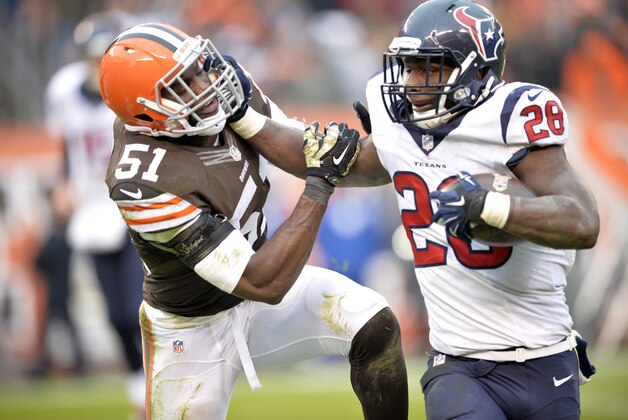 Houston Texans running back Alfred Blue (28) fights for yardage against Cleveland Browns outside linebacker Barkevious Mingo (51) in the fourth quarter of an NFL football game Sunday, Nov. 16, 2014, in Cleveland. (AP Photo/David Richard)