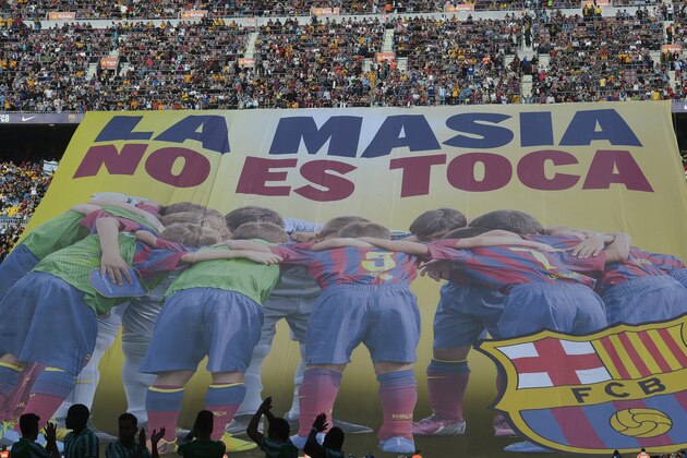 FC Barcelona's supporters unveil a giant banner reading in Catalan 'La Masia, don't touch it' prior to the Spanish La Liga soccer match between FC Barcelona and Betis at the Camp Nou stadium in Barcelona, Spain, Saturday, April 5, 2014. Barcelona has been