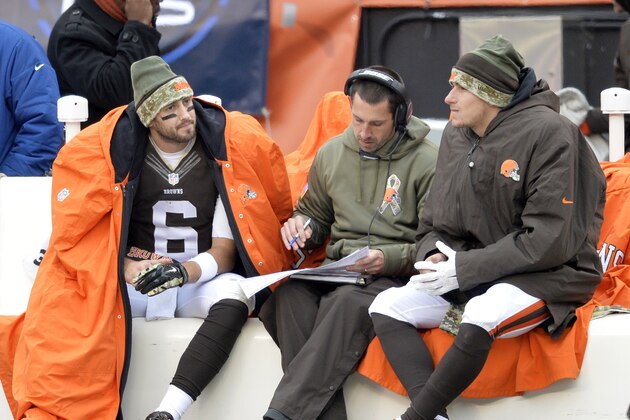 Cleveland Browns offensive coordinator Kyle Shanahan, center, goes over the play sheet with quarterbacks Brian Hoyer (6) and Johnny Manziel in the third quarter of an NFL football game against the Houston Texans Sunday, Nov. 16, 2014, in Cleveland. (AP Photo/David Richard)