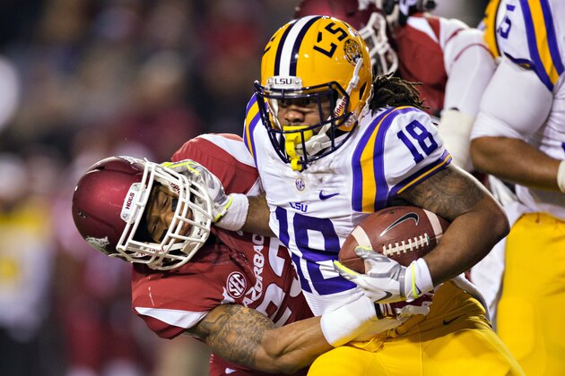 FAYETTEVILLE, AR - NOVEMBER 15:  Terrence Magee #18 of the LSU Tigers stiff arms Tevin Mitchel #23 of the Arkansas Razorbacks at Razorback Stadium on November 15, 2014 in Fayetteville, Arkansas.  (Photo by Wesley Hitt/Getty Images)