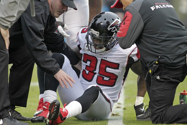Team members assist Atlanta Falcons' Antone Smith (35) after Smith was injured in the second half of an NFL football game against the Carolina Panthers in Charlotte, N.C., Sunday, Nov. 16, 2014. (AP Photo/Bob Leverone)