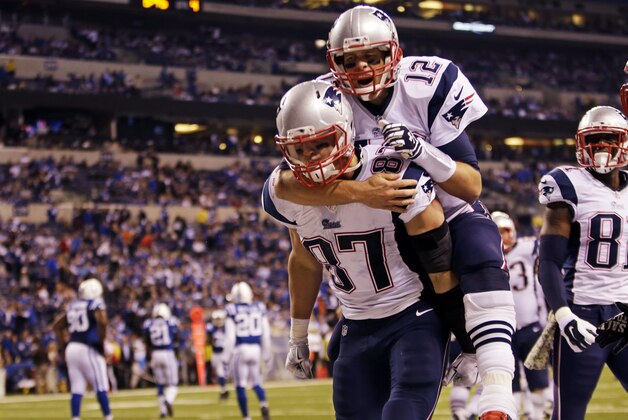 New England Patriots quarterback Tom Brady, top, jumps on the back of tight end Rob Gronkowski after Gronkowski scored a touchdown against the Indianapolis Colts during the second half of an NFL football game in Indianapolis, Sunday, Nov. 16, 2014. (AP Photo/AJ Mast)