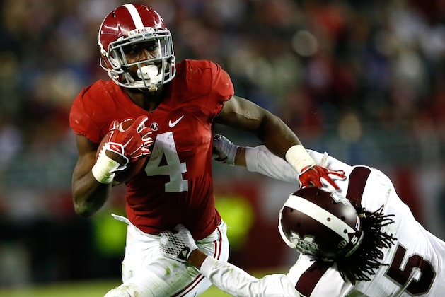 TUSCALOOSA, AL - NOVEMBER 15:  T.J. Yeldon #4 of the Alabama Crimson Tide stiff arms Jamerson Love #5 of the Mississippi State Bulldogs at Bryant-Denny Stadium on November 15, 2014 in Tuscaloosa, Alabama.  (Photo by Kevin C. Cox/Getty Images)