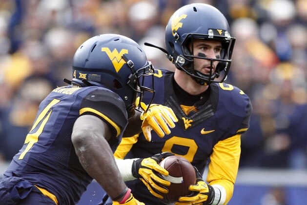 MORGANTOWN, WV - NOVEMBER 01:  Clint Trickett #9 of the West Virginia Mountaineers fakes a hand off to Wendell Smallwood #4 of the West Virginia Mountaineers during the game against the TCU Horned Frogs on November 1, 2014 at Mountaineer Field in Morgantown, West Virginia.  (Photo by Justin K. Aller/Getty Images)