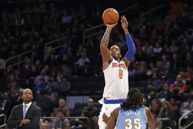 Denver Nuggets head coach Brian Shaw watches, far left, as New York Knicks guard J.R. Smith (8) shoots over the defense of Denver Nuggets forward Kenneth Faried (35) in the second half of an NBA basketball game at Madison Square Garden in New York, Sunday, Nov. 16, 2014. Smith and Carmelo Anthony each had 28 points to help the Knicks defeat the Nuggets 109-93. (AP Photo/Kathy Willens)