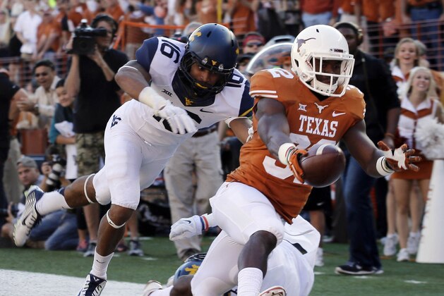 FILE - In this Nov. 8, 2014, file photo, Texas’ Johnathan Gray (32) is pursued by West Virginia’s Terrell Chestnut (16) as he reaches for the goal line to score a touchdown during the first half of an NCAA college football game in Austin, Texas. For the Longhorns to get to the postseason in Charlie Strong's first season as coach, they'll need to win this game in Stillwater, Oklahoma, or beat No. 6 TCU on Thanksgiving night in Austin, Texas. (AP Photo/Eric Gay, File)