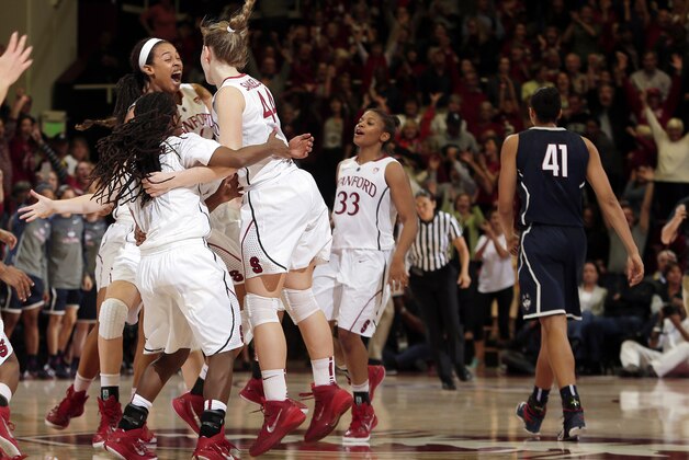 Stanford players celebrate after a 88-86 overtime win over Connecticut during an NCAA college basketball game on Monday, Nov. 17, 2014, in Stanford, Calif. (AP Photo/Marcio Jose Sanchez)