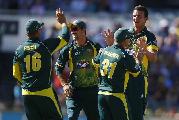 Australia's Josh Hazlewood, right, is congratulated by team mates after taking the wicket of South Africa's Quinton de Kock during their second one-day international cricket match in Perth, Australia, Sunday, Nov. 16, 2014. (AP Photo/Theron Kirkman)