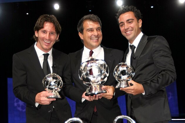 The best forward and player of the year FC Barcelona's Argentinian Lionel Messi, left,  the best midfielder of the year FC Barcelona's Xavi Hernandez, right, and  Barcelona's President Joan Laporta,  pose for photographers  during the UEFA Champions League draw, at the Grimaldi Forum, in Monaco, Thursday, Aug. 27, 2009. The UEFA champions League Cup is in front. (AP Photo/Claude Paris)