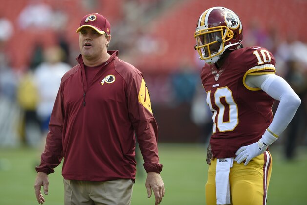 Washington Redskins head coach Jay Gruden, right, stands with quarterback Robert Griffin III (10) before an NFL football game against the Jacksonville Jaguars, Sunday, Sept. 14, 2014, in Landover, Md. (AP Photo/Nick Wass)