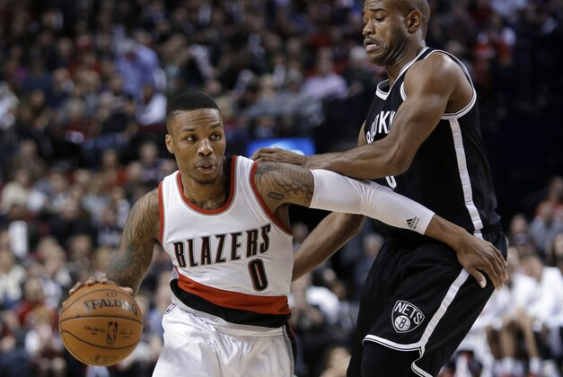 Portland Trail Blazers guard Damian Lillard, left, drives against Brooklyn Nets' Jarrett Jack during the second half of an NBA basketball game in Portland, Ore., Saturday, Nov. 15, 2014. Lillard led the Trail Blazers in scoring with 28 points as they won 97-87.(AP Photo/Don Ryan)