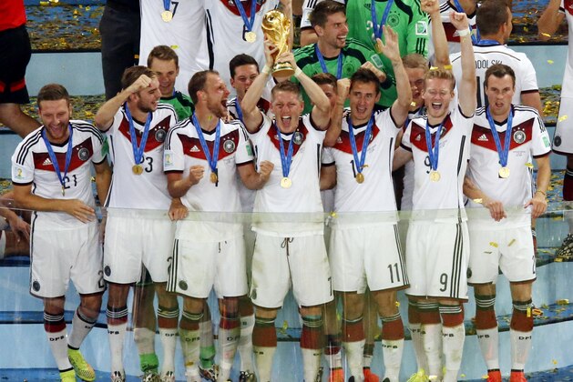 Germany's Bastian Schweinsteiger holds up the trophy as the German team celebrates after winning the World Cup final soccer match between Germany and Argentina at the Maracana Stadium in Rio de Janeiro, Brazil, Sunday, July 13, 2014. Mario Goetze volleyed in the winning goal in extra time to give Germany its fourth World Cup title with a 1-0 victory over Argentina on Sunday. (AP Photo/Fabrizio Bensch, Pool)