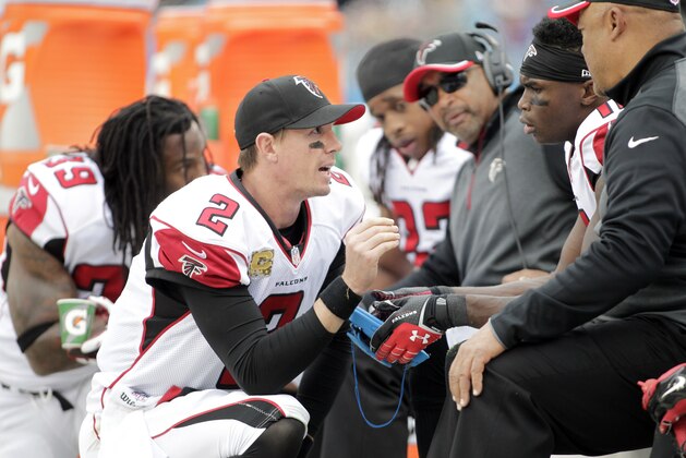 Atlanta Falcons' Matt Ryan (2) huddles with players and coaches on the sidelines during the first half of an NFL football game against the Carolina Panthers in Charlotte, N.C., Sunday, Nov. 16, 2014. The Falcons won 19-17. (AP Photo/Bob Leverone)