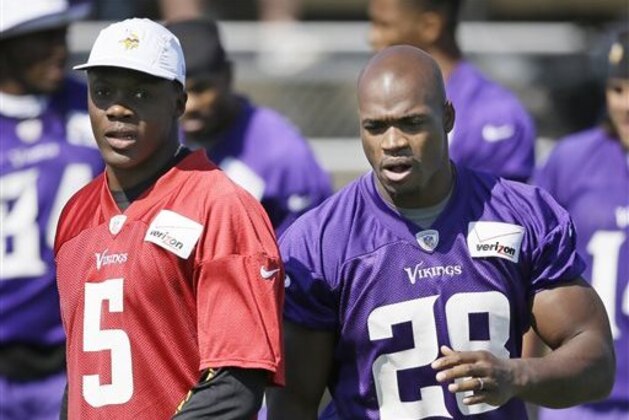 FILE - In this July 25, 2014, file photo, Minnesota Vikings quarterback Teddy Bridgewater (5) talks with running back Adrian Peterson during NFL football training camp in Mankato, Minn. There was always a chance that Bridgewater was going to take over as quarterback for the Vikings. But take over as face of the franchise? With Peterson away facing child abuse charges, that's exactly what could be happening. (AP Photo/Charlie Neibergall, File)
