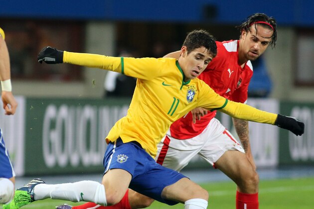 Brazil's Oscar, left, and Austria's Martin Harnik, right, in action during in an International friendly soccer match between Austria and Brazil in Vienna, Austria, Tuesday, Nov. 18, 2014. (AP Photo/Ronald Zak)