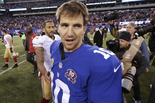 New York Giants quarterback Eli Manning (10) leaves the field after talking to San Francisco 49ers' Colin Kaepernick (7) during the second half of an NFL football game Sunday, Nov. 16, 2014, in East Rutherford, N.J. The 49ers won the game 16-10. (AP Photo/Julio Cortez)