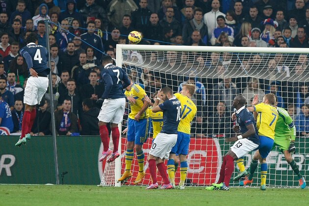 France's defender and Captain Raphael Varane, left, jumps for the ball and scores against Sweden during the international friendly soccer match between France and Sweden, at the Velodrome Stadium, in Marseille, southern France, Tuesday, Nov. 18, 2014. (AP Photo/Claude Paris)