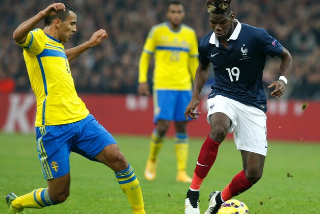 France's midfielder Paul Pogba, right, challenges for the ball with Sweden's forward Nabil Bahoui, during an international friendly soccer match between France and Sweden, at the Velodrome Stadium, in Marseille, southern France, Tuesday, Nov. 18, 2014. (AP Photo/Claude Paris)