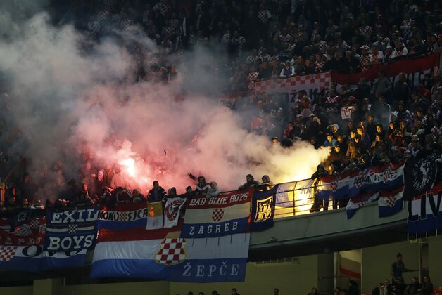 Croatia's supporters light their flares during the Euro 2016 qualifying soccer match between Italy and Croatia, at the San Siro stadium in Milan, Italy, Sunday, Nov. 16, 2014. The match was temporarily suspended following the launch of flares and clashes with Italian riot police on the stands. (AP Photo/Antonio Calanni)