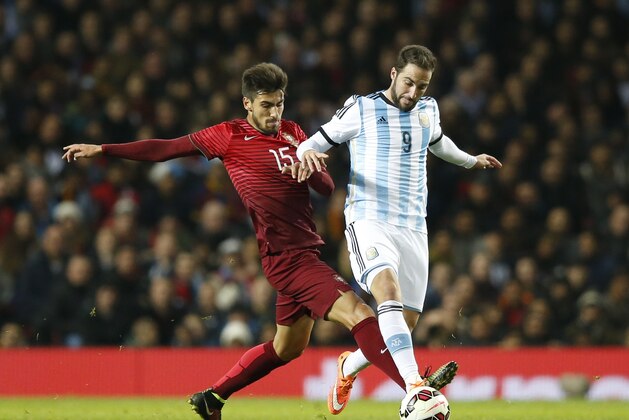 Andre Gomes of Portugal, left, challenges Gonzalo Higuain of Argentina during their International Friendly soccer match at Old Trafford Stadium, Manchester, England, Tuesday Nov. 18, 2014. (AP Photo/Jon Super)