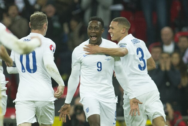 England's Danny Welbeck celebrates with team mates Wayne Rooney, left, and Kieran Gibbs after scoring against Slovenia, during their Euro 2016 Group E qualifying soccer match at Wembley Stadium, London, Saturday, Nov. 15, 2014 (AP Photo/Bogdan Maran)