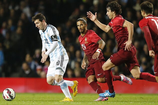 Lionel Messi of Argentina, left, runs clear of the Portugal defence during their International Friendly soccer match at Old Trafford Stadium, Manchester, England, Tuesday Nov. 18, 2014. (AP Photo/Jon Super)