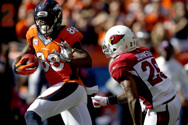 Denver Broncos wide receiver Demaryius Thomas (88) tries to avoid Arizona Cardinals free safety Rashad Johnson (26) during the first half of an NFL football game, Sunday, Oct. 5, 2014, in Denver. (AP Photo/David Zalubowski)