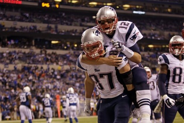 Tom Brady, de los Patriots de Nueva Inglaterra, salta a la espalda del tight end Rob Gronkowski, quien anotó un touchdown, en el partido del domingo 16 de noviembre de 2014, frente a los Colts de Indianápolis  (AP foto/AJ Mast)