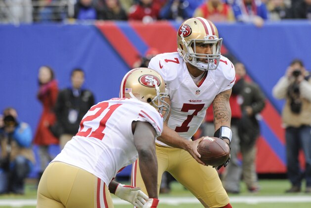 San Francisco 49ers quarterback Colin Kaepernick (7) hands the ball to Frank Gore (21) during the first half of an NFL football game Sunday, Nov. 16, 2014, in East Rutherford, N.J.  (AP Photo/Bill Kostroun)