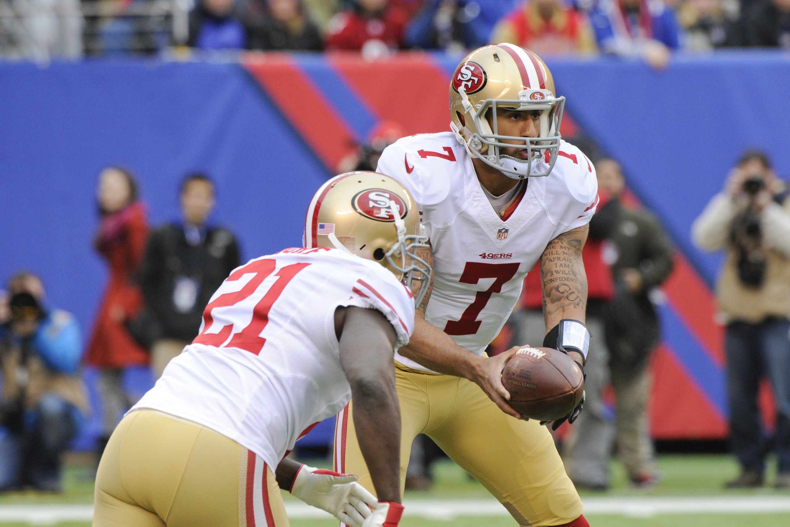 San Francisco 49ers quarterback Colin Kaepernick (7) hands the ball to Frank Gore (21) during the first half of an NFL football game Sunday, Nov. 16, 2014, in East Rutherford, N.J.  (AP Photo/Bill Kostroun)