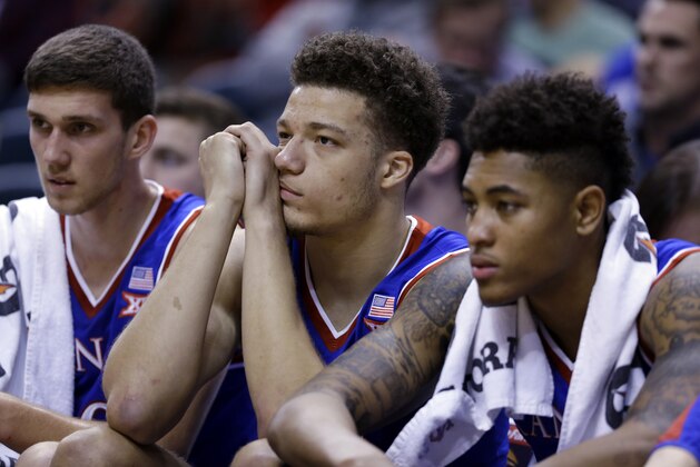 Kansas players, from left, Sviatoslav Mykhailiuk, Brannen Greene and Kelly Oubre Jr. sits on the bench in the finals minutes of the second half of an NCAA college basketball game against Kentucky in Indianapolis, Tuesday, Nov. 18, 2014. Kentucky won 72-40. (AP Photo/Michael Conroy)