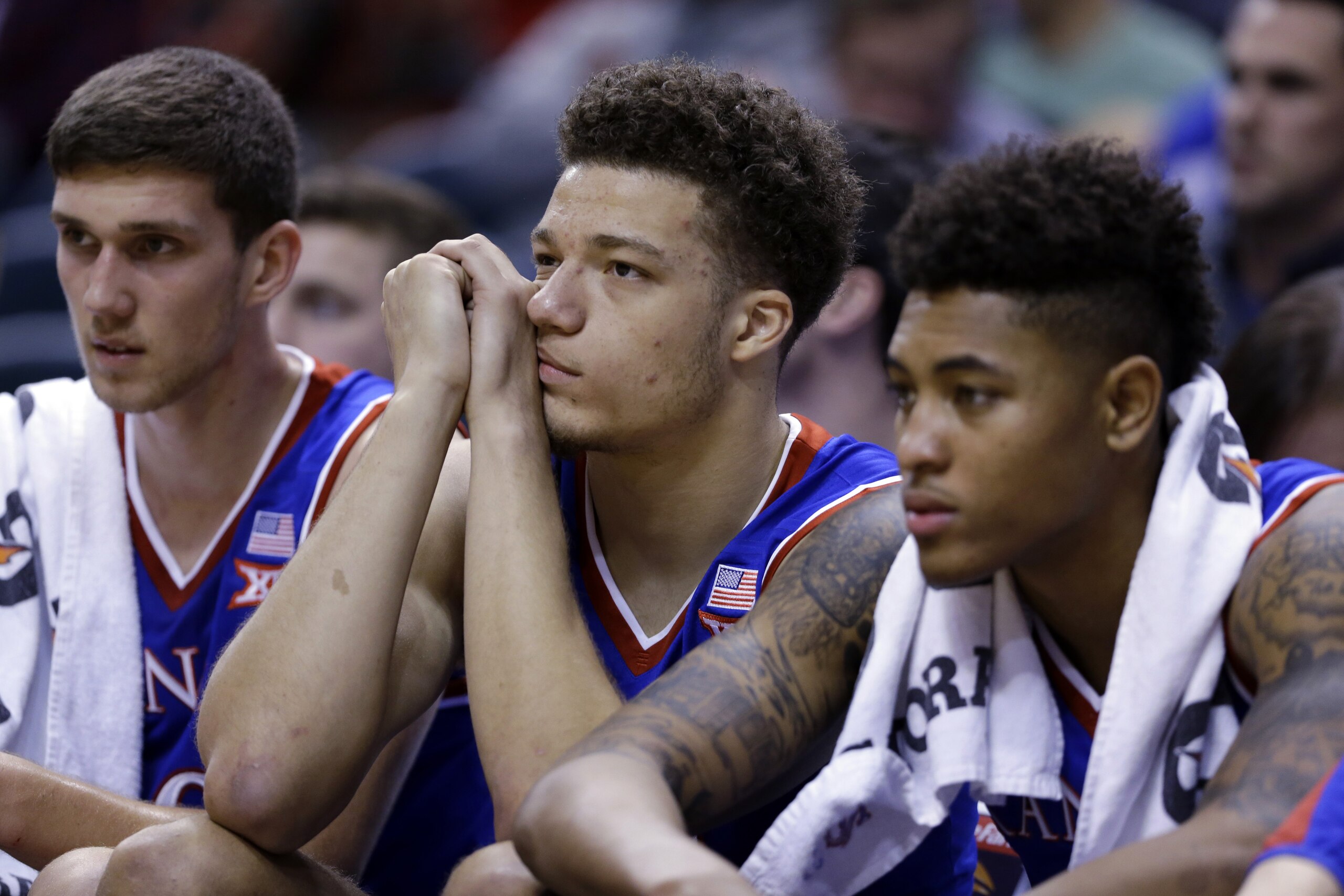 Kansas players, from left, Sviatoslav Mykhailiuk, Brannen Greene and Kelly Oubre Jr. sits on the bench in the finals minutes of the second half of an NCAA college basketball game against Kentucky in Indianapolis, Tuesday, Nov. 18, 2014. Kentucky won 72-40. (AP Photo/Michael Conroy)