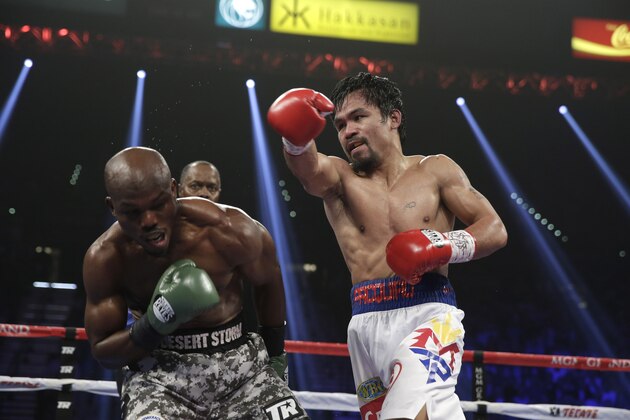 Manny Pacquiao, right, of the Philippines, throws a right against Timothy Bradley, in their WBO welterweight title boxing fight Saturday, April 12, 2014, in Las Vegas. (AP Photo/Isaac Brekken)