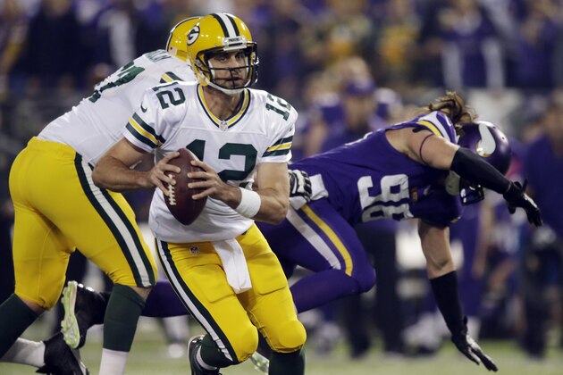 Green Bay Packers quarterback Aaron Rodgers (12) runs in the first half of an NFL football game against the Minnesota Vikings, Sunday, Oct. 27, 2013, in Minneapolis. (AP Photo/Jim Mone)