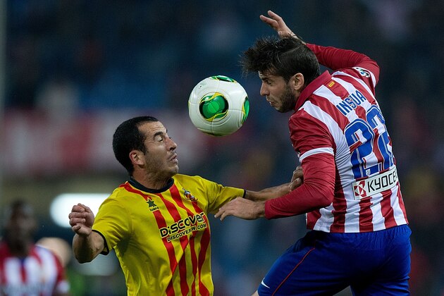 MADRID, SPAIN - DECEMBER 18: Emiliano Insua (R) of Atletico de Madrid competes for the ball with Xapi Arnau (L) of UE Sant Andreu during the Copa del Rey Round of 32 second leg match between Club Atletico de Madrid and Sant Andreu at Vivente Calderon Stadium on December 18, 2013 in Madrid, Spain.  (Photo by Gonzalo Arroyo Moreno/Getty Images)