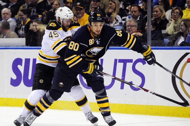 Boston Bruins defenseman Joe Morrow (45) grabs Buffalo Sabres right winger Chris Stewart (80) as he looks to pass the puck during the first period of an NHL hockey game Thursday, Oct., 30, 2014, in  Buffalo , N.Y. (AP Photo/Gary Wiepert)