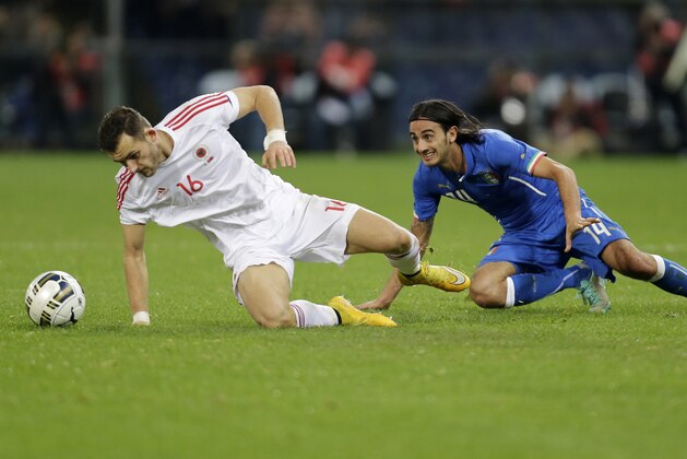 Italy's Alberto Aquilani, right, challenges for the ball with Albania's Sokol Cikalleschi during the friendly soccer match between Italy and Albania, at the Luigi Ferraris stadium in Genoa, Italy, Tuesday, Nov. 18, 2014. (AP Photo/Antonio Calanni)