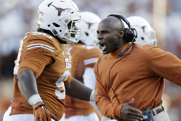 Texas Longhorns head coach Charlie Strong, right, celebrates with Malcom Brown, left, during the second half of an NCAA college football game against West Virginia, Saturday, Nov. 8, 2014, in Austin, Texas.  Texas won 33-16. (AP Photo/Eric Gay)