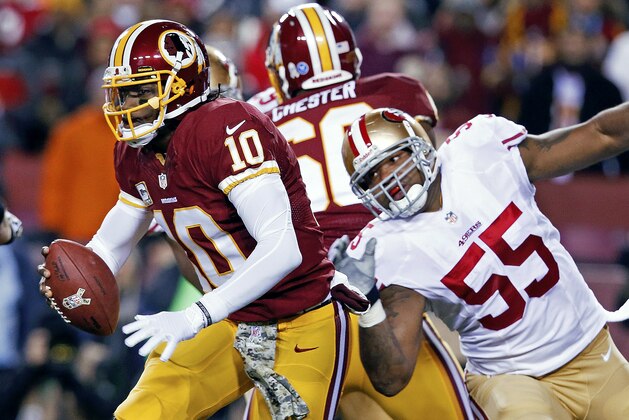 Washington Redskins quarterback Robert Griffin III scrambles away from San Francisco 49ers outside linebacker Ahmad Brooks during the first half of an NFL football game in Landover, Md., Monday, Nov. 25, 2013. (AP Photo/Alex Brandon)