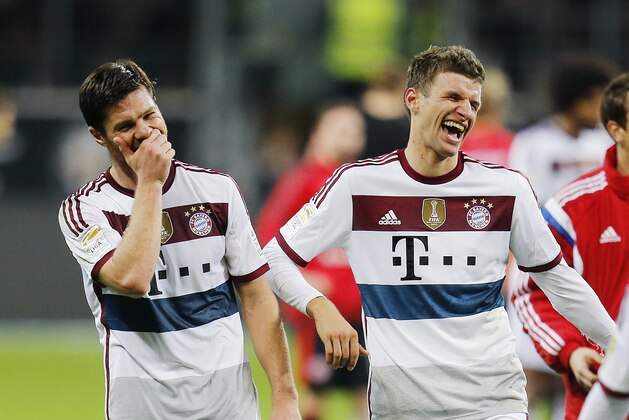 Bayern's Thomas Mueller, right, and Bayern's Xabi Alonso joke after the German first division Bundesliga soccer match between Eintracht Frankfurt and Bayern Munich in the Commerzbank Arena in Frankfurt, Germany, Saturday, Nov. 8, 2014. (AP Photo/Michael Probst)