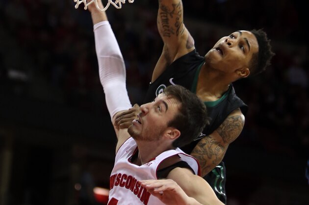 Nov 19, 2014; Madison, WI, USA; Green Bay Phoenix guard Keifer Sykes (top) drives over Wisconsin Badgers Frank Kaminsky to score a basket during the first half at the Kohl Center. Mandatory Credit: Mary Langenfeld-USA TODAY Sports