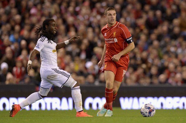 LIVERPOOL, ENGLAND - OCTOBER 28:  Jordan Henderson of Liverpool is atckled by Bafetimbi Gomis of Swansea during the Capital One Cup Fourth Round match between Liverpool and Swansea City at Anfield on October 28, 2014 in Liverpool, England.  (Photo by Gareth Copley/Getty Images)